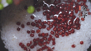 將炒好的食材和大米、紅豆一起放進(jìn)電飯鍋煮。