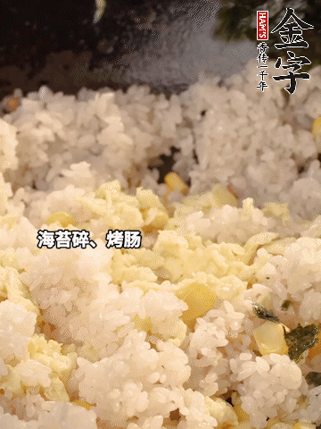 剩米飯下鍋炒散，依次下玉米粒、雞蛋、烤腸、海苔碎翻炒均勻。