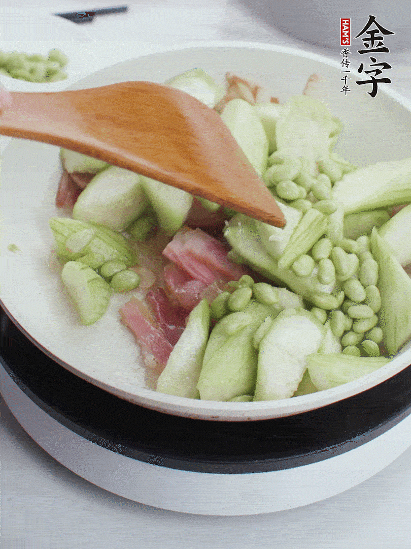 依次下絲瓜、青豆翻炒，炒至絲瓜打蔫縮小。