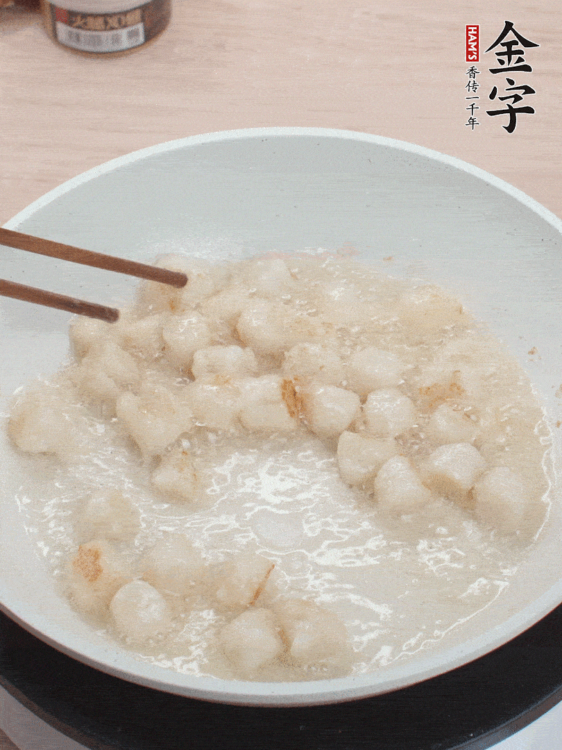 油溫4成熱，鮮貝蘸干淀粉下鍋煎，一面微黃后翻面。