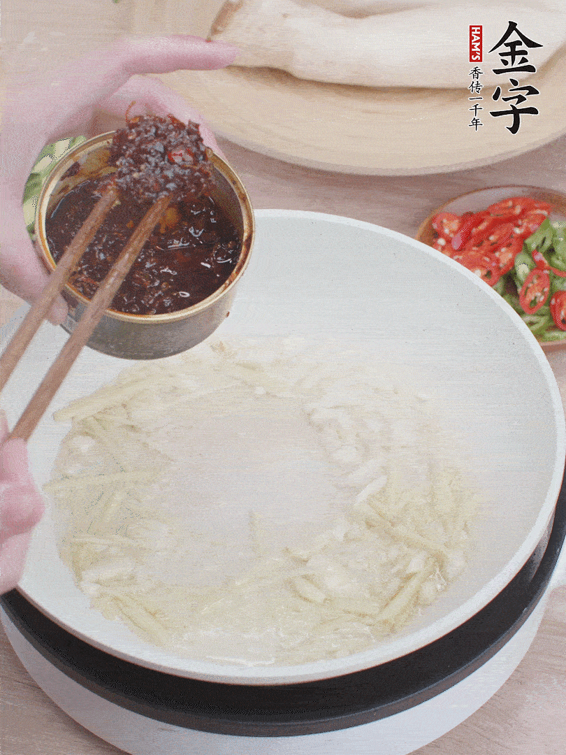 起鍋熱油，姜蒜、金字火腿干貝醬煸香。