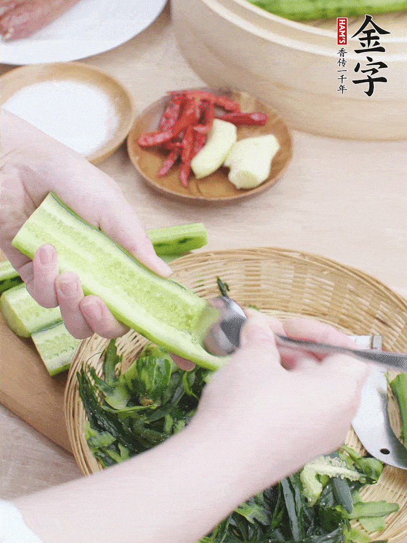 黃瓜削皮，對半切開，勺子挖去內(nèi)瓤，斜刀切片。青蒜斜刀切段。
