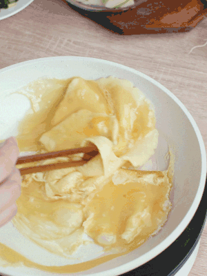 油6成熱時，下雞蛋液，邊緣凝固時翻拌成塊狀。