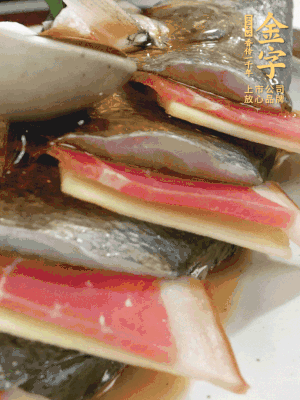 魚肚中塞蔥結(jié)、火腿片，魚身上碼放姜片、火腿片，倒入混合的料汁。