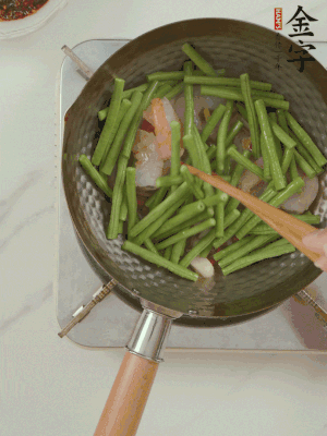 下掰好的缸豆段翻炒，略燜煮。
