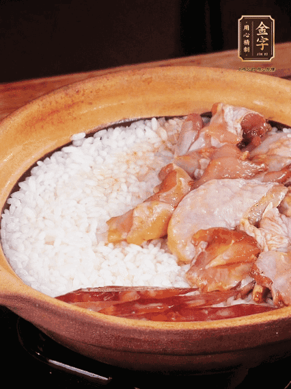 煮到椰子水微微收干轉(zhuǎn)小火，快速均勻鋪上雞肉、金字香腸